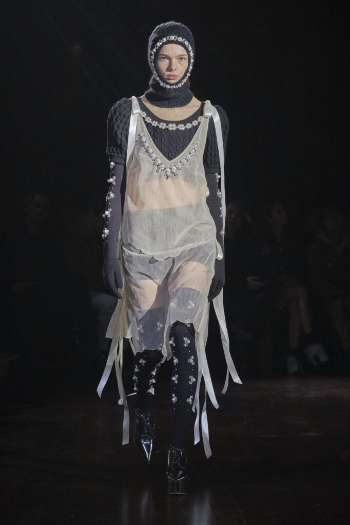 Model walking for SImone Rocha AW22 London Fashion Week show wearing sheer dress and embellished balaclava 