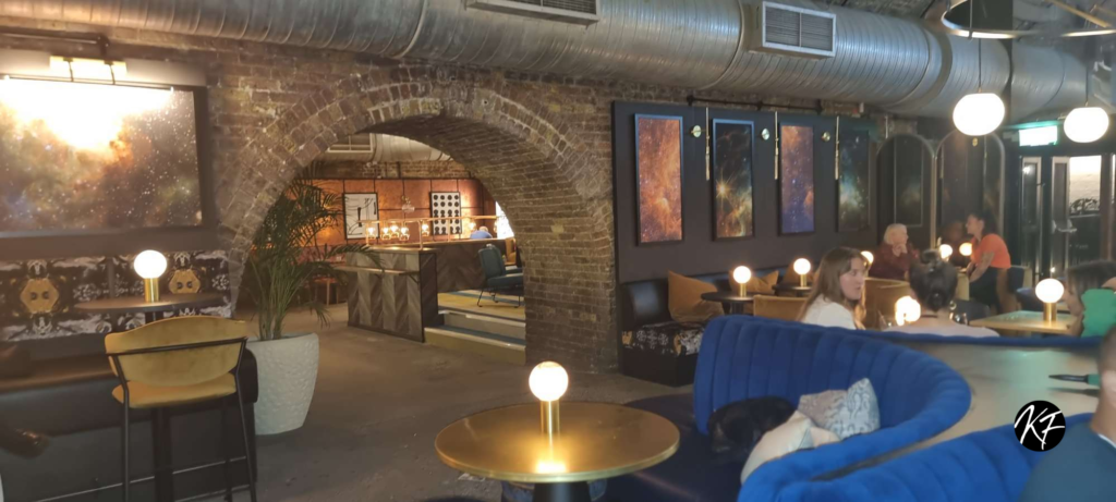 Inside the venue of the Viaduct- Industrial exposed brick walls surrounding a selection of different tables and seating arrangements
