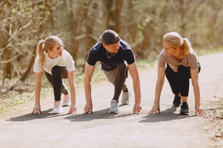 one man and 2 women on each of his side, set to race on a track.